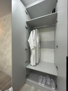 einen begehbaren Kleiderschrank mit weißen Handtüchern und Schuhen in der Unterkunft город Балхаш, Шашубая 8г in Zhezdi