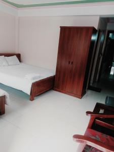 Un dormitorio con una cama y un armario de madera. en Homey Hotel, en Lào Cai