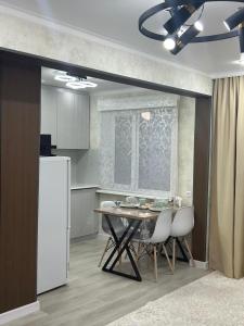 eine Küche mit Tisch und Stühlen und einem Kühlschrank in der Unterkunft город Балхаш, Шашубая 8г in Zhezdi
