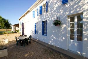 a table and chairs sitting outside of a white building at Gites La Bigorre, Charente Maritime in Saint-Germain-du-Seudre