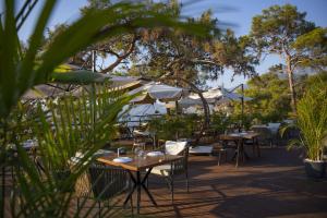 a restaurant with tables and chairs and umbrellas at Lov Faralya Adults Only in Faralya