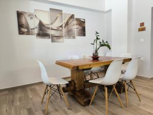 a dining room with a wooden table and white chairs at Neva Apartments by the Beach in Makry Gialos +36 photos
