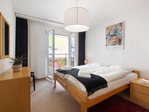 Un dormitorio con una cama y una ventana grande en Apartment Allod Park Haus C 306 by Interhome, en Davos