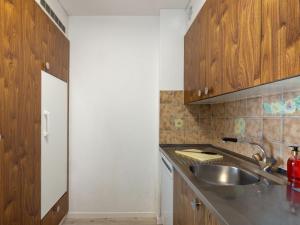 Una cocina con gabinetes de madera y un fregadero. en Apartment Allod Park Haus C 306 by Interhome, en Davos