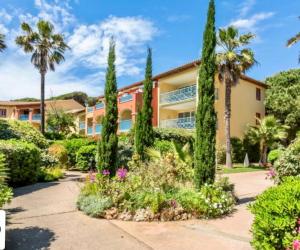 a house with trees and flowers in front of it at BADINE BEACH 5 personnes vue jardin avec climatisation in Hyères