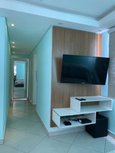 un soggiorno con una TV a schermo piatto su una parete di Apartamento Inteiro 2 Quartos a São José dos Campos