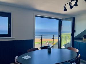 Un comedor con mesa y vista al mar. en Penthouse North Sea Front, en Saltburn-by-the-Sea