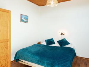 a bedroom with a bed with a blue blanket at Holiday Home Sicard-4 by Interhome in Mimizan-Plage