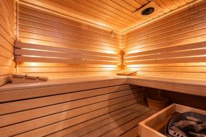 a wooden sauna with a bench in it at Flatbook Willa Spa Mikoszewo - 4 sypialni, jacuzzi i sauna in Nickelswalde