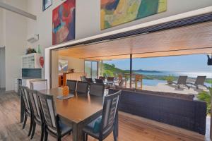 een eetkamer met een tafel en stoelen en een groot raam bij Serene Oceanview Villa with Pool in Playa Flamingo