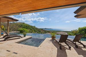 a patio with two chairs and a swimming pool at Oceanview Villa in Mar Vista, Infinity Pool in Playa Flamingo