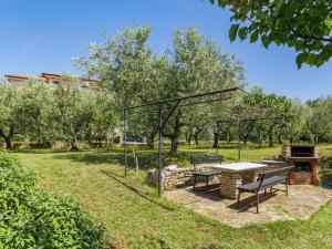 a picnic table and a grill in a park at Apartment Olivo-2 by Interhome in Karpinjan