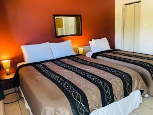 2 Betten in einem Zimmer mit orangefarbenen Wänden in der Unterkunft Attitude Montagne in Saint Adolphe D'Howard