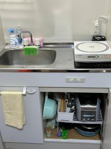 eine Küchentheke mit einer Spüle und einem Herd in der Unterkunft 吉祥民宿 in Kyoto + 23 Fotos
