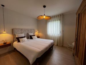 a bedroom with a large white bed with two pillows at Ty Rosc'OFF, Plain-pied de charme, tout récent, à proximité immédiate du centre de Roscoff in Roscoff +22 photos