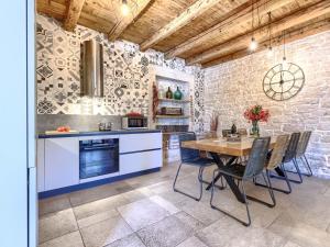 a kitchen and dining room with a table and chairs at Holiday Home Villa Radovani by Interhome in Višnjan