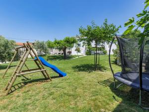 a playground with a slide and a swing at Holiday Home Villa Radovani by Interhome in Višnjan