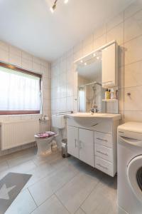 een witte badkamer met een wastafel en een toilet bij Apartment Am Hohen Bogen-11 by Interhome in Arrach +16 foto's