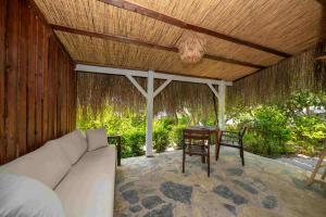 a porch with a couch and a table and a wooden roof at Lov Faralya Adults Only in Faralya
