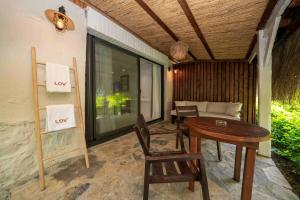 a porch with a table and chairs and a couch at Lov Faralya Adults Only in Faralya