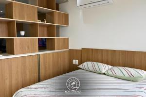 a bedroom with a bed with a wooden headboard and pillows at Apto Studio para 03 pessoas em Torres - Ar condicionado - Smart TV - Wifi - Vaga de garagem - Lavanderia - Aceita Pet - 400mts da Praia in Torres
