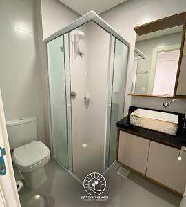 a bathroom with a toilet and a glass shower at Apto Studio para 03 pessoas em Torres - Ar condicionado - Smart TV - Wifi - Vaga de garagem - Lavanderia - Aceita Pet - 400mts da Praia in Torres