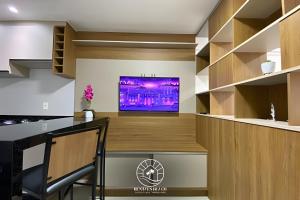 a kitchen with a bar with a tv on a counter at Apto Studio para 03 pessoas em Torres - Ar condicionado - Smart TV - Wifi - Vaga de garagem - Lavanderia - Aceita Pet - 400mts da Praia in Torres