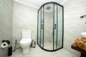 a bathroom with a toilet and a glass shower at Lov Faralya Adults Only in Faralya