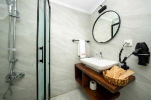 a bathroom with a sink and a mirror and a shower at Lov Faralya Adults Only in Faralya
