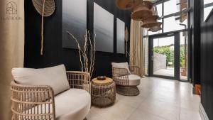a living room with wicker chairs and a table at Flatbook Willa Spa Mikoszewo - 4 sypialni, jacuzzi i sauna in Nickelswalde