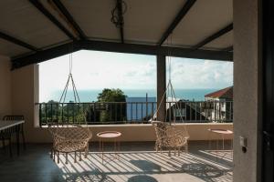 a balcony with chairs and a table and a large window at Limonura in Ts'ikhisdziri