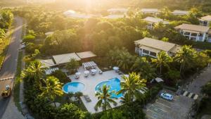 an aerial view of a resort with a pool and palm trees at RESERVA IMBASSAI - APARTAMENTO TD 17 202 BUGANVILIAS in Imbassai