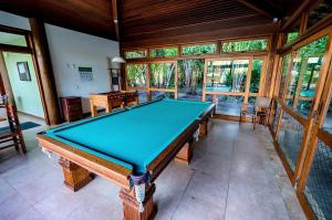a pool table in a room with windows at RESERVA IMBASSAI - APARTAMENTO TD 17 202 BUGANVILIAS in Imbassai