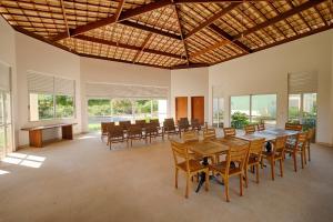 a large dining room with a table and chairs at RESERVA IMBASSAI - APARTAMENTO TD 17 202 BUGANVILIAS in Imbassai +38 photos