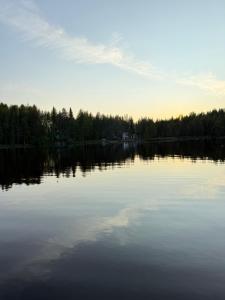 a large body of water with trees in the background at Pirttiaitta in Oulu