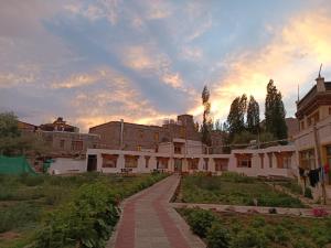a building with a walkway in front of a courtyard at The Kurja Garden in Leh +17 photos