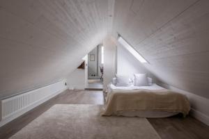 a white bedroom with a bed in a attic at Renovated apartment with balcony in Visby in Visby