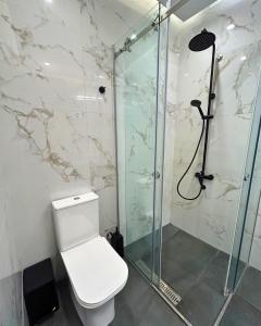 a bathroom with a toilet and a glass shower at Cosy Paradise in Palouki +11 photos