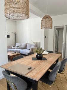 Un comedor con mesa y sillas de madera. en Gare - Visitation grand Appartement , 1 chambre, en Angers