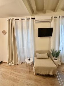 a living room with white curtains and a couch and a table at Lumière Carmela in Corfu