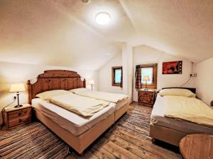 a bedroom with two beds and two tables and two lamps at Holiday Home Farm Eben by Interhome in Ginzling