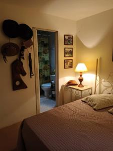 a bedroom with a bed and a door to a bathroom at Suítes na montanha in Águas de Lindóia