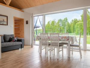 jadalnia ze stołem i krzesłami oraz dużym oknem w obiekcie Holiday Home Zagroda nad Krutynią by Interhome w mieście Spychowo +28 zdjęć