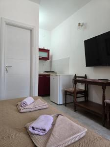 a room with two towels on a bed with a television at Kostic Apartments in Buljarica