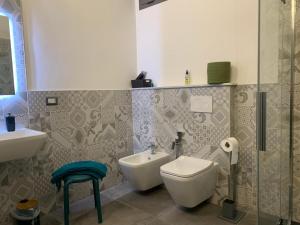 ein Badezimmer mit Toilette und Waschbecken in der Unterkunft Loft di Gianluca e Grazia in Maracalagonis + 14 Fotos