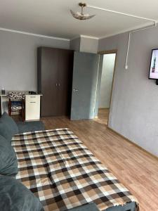 a living room with a couch and a tv in it at Квартира посуточно in Uralsk