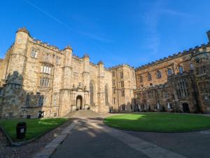 a large stone building with a green lawn in front at Cosy Cottage 3 in Durham