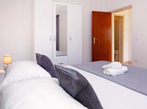a bedroom with two beds and a mirror at Apartments Villa Senija in Prizba