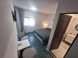a small room with a bed and a mirror at Maison Legion in Lupeni