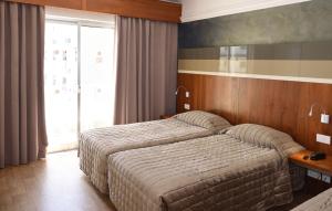 a hotel room with a bed and a window at Topaz Hotel in St Paul's Bay